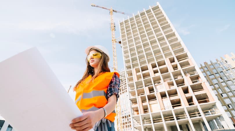 A female engineer on a construction site, reviewing blueprints