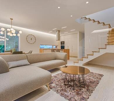 Interior of a modern house, showing an open-plan living room with a large sofa and minimalist decor